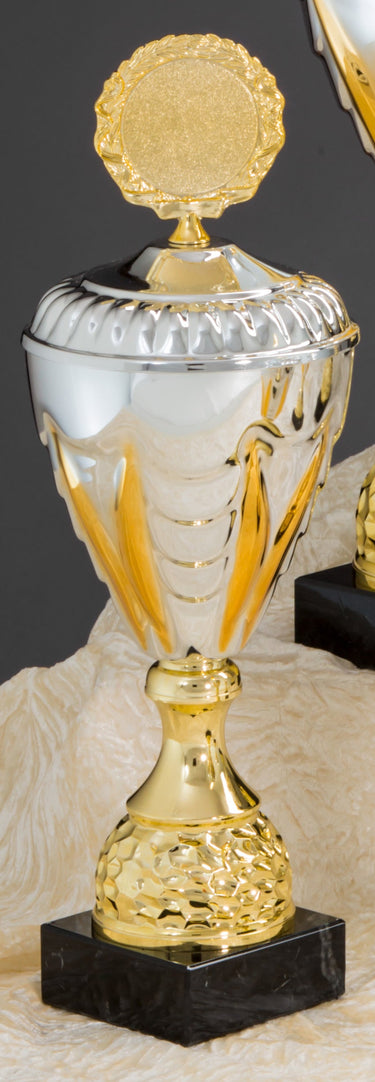 Die „Pokale Bensheim 6-er Pokalserie 275 mm – 508 mm PK757910-6-E50“ besteht aus einem gold-silbernen Pokal mit dekorativer Oberseite und schwarzem Boden, der vor einem beigen Stoffhintergrund präsentiert wird.
